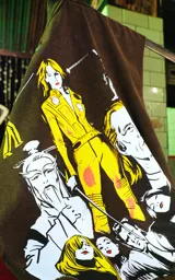 Sudadera sin mangas (tipo chaleco) color marrón óxido con estampado gráfico en la espalda inspirado en la película Kill Bill, con personajes de estilo cómic.