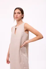 Vestido midi azul marino sin mangas, con escote redondo y detalle de abertura en forma de lágrima en el pecho. Diseño holgado con corte asimétrico y volado en el ruedo.