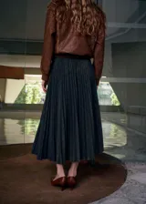 Falda midi plisada de color gris oscuro, con corte acampanado y diseño fluido.