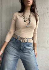 Polera de cuello alto y manga larga, confeccionada en tejido de algodón con textura acanalada y ajuste al cuerpo.