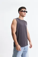 Musculosa de corte oversize color marrón, con escote redondo y estampa gráfica pequeña en el pecho.