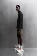 Sudadera negra de tejido técnico Polartec© con interior en estructura waffle. Tiene cuello alto con cremallera, mangas largas con puños ajustables con abertura para el pulgar y logo Polartec© bordado en el hombro.