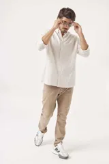 Camisa de lino color verde claro, de corte recto, con cuello abotonado y mangas largas.