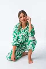 Camisa amplia de algodón color verde con estampado de hojas blancas, corte amplio, terminaciones cuidadas, botones ocultos y tejido ligero.