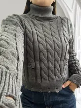 Sweater gris de punto trenzado, con cuello alto y terminaciones rotas.