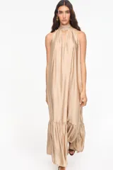 Vestido largo de viscosa color bordó, con cuello halter alto, corte holgado y volante fruncido en el bajo.