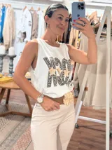 Musculosa negra de calce holgado con estampa frontal que dice ROCK, donde las letras tienen un diseño de animal print y estrellas doradas brillantes.