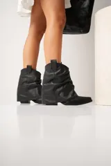 Botas texanas de cuero gamuzado color marrón, con caña media y punta fina.