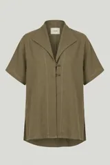 Sobrecamisa de lino verde militar, de manga corta, con cuello solapa y cierre frontal con botones tipo pastilla. Presenta pespuntes contrastantes y aberturas laterales en el dobladillo.
