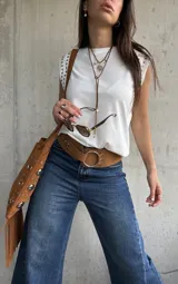 Remera sin mangas de algodón blanco, con cuello redondo y detalle de tachas metálicas en los hombros.