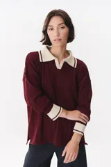 Sweater de punto color marrón con cuello polo en contraste color crema. Presenta diseño de rayas verticales texturizadas, mangas largas con puños en color crema y corte holgado.