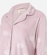 Pijama de dos piezas estilo americano confeccionado en plush suave. Incluye una camisa de manga larga con cuello en V, solapa y cierre frontal con botones, y un pantalón largo de corte recto con cintura elástica y cordón de ajuste. Presenta un estampado de lunares en toda la prenda.