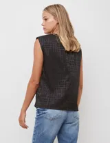 Blusa sin mangas negra con textura de cuadros en relieve, cuello redondo con frunce y hombreras.