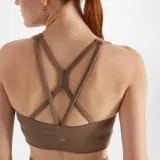 Top deportivo New Balance color marrón, de calce ajustado y breteles anchos. Confeccionado en tejido acanalado de poliéster reciclado y elastano, con tecnología NB DRY de secado rápido y almohadillas removibles.