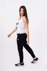 Pantalón de jogging gris con cintura elástica y logo de alas estampado en negro en el muslo.