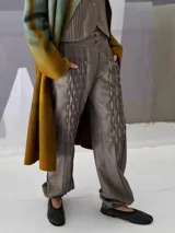 Pantalón babucha de lana color gris con textura en las piernas y elástico con broches en los tobillos.