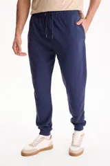 Pantalón deportivo negro sin friza con puño en los tobillos y cordón ajustable en la cintura.