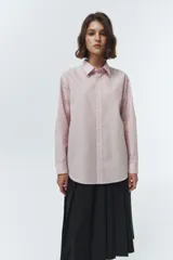 Camisa de algodón y nylon, color rosa pálido con finas rayas verticales blancas. Presenta un cuello clásico, botones frontales y un calce oversized.