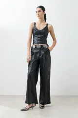 Top negro de cuero sintético con breteles finos y corte ajustado.