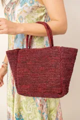 Bolso tipo tote color bordó, confeccionado en material tejido con textura natural, doble asa de mano y diseño estructurado.