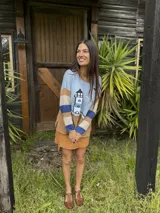 Sweater de tejido de punto de algodón, con diseño de faro, mar y aves bordadas a mano, cuello redondo y mangas largas con rayas horizontales en tonos celeste, tostado y azul.
