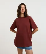 Remera oversized de manga corta color bordó, de corte amplio con cuello redondo y diseño liso.