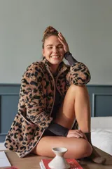 Campera de polar con textura suave y diseño estampado de animal print. Cuenta con cierre frontal completo, cuello alto y bolsillos frontales aplicados.