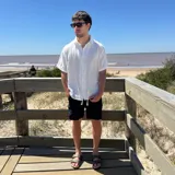 Camisa blanca de lino con estampado circular negro en la espalda y corte boxy.