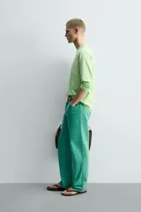 Jeans de mezclilla de corte recto, tiro medio, color verde vibrante con efecto lavado. Presenta cierre frontal con cremallera y botón, y cinco bolsillos.