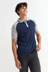 Remera tipo polo de manga corta con diseño combinado, cuerpo en azul marino y mangas y cuello en gris melange. Presenta cierre frontal con botones.