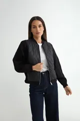 Campera tipo bomber con frente acolchado en diseño de rombos y mangas de tejido de punto acanalado. Presenta cierre frontal metálico y cuello, puños y ruedo en tejido elástico.