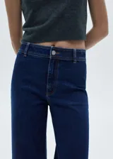 Jeans tiro alto de corte culotte, color azul oscuro, con bajo deshilachado y cierre de cremallera y botón.