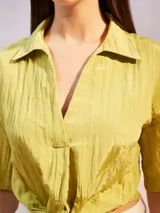 Camisa de textura arrugada en color verde lima, con cuello clásico, mangas cortas y diseño frontal anudado en la cintura.