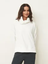 Polera de manga larga en color negro, confeccionada en tejido de punto con textura acanalada fina. Presenta un cuello alto tipo polera, corte holgado y puños ajustados.