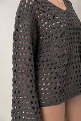 Buzo gris de tejido calado con escote en V y detalle de cinta intercalada al tono.