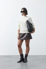 Polera de tejido de punto con cuello alto y diseño de rayas verticales sutiles. Presenta un ajuste al cuerpo y mangas largas.