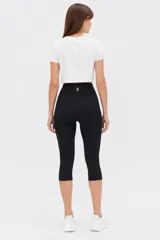 Calza biker corta negra de tiro alto, confeccionada en poliéster con diseño ajustado al cuerpo y largo a la rodilla.