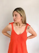 Vestido blanco de lino con breteles finos que se atan en los hombros.