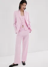 Pantalón de lino color rosado, de diseño recto y tiro medio, con trabillas, bolsillos laterales y cierre oculto.