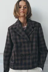 Chaqueta corta de Zara Woman Collection, confeccionada en mezcla de algodón con estampado de cuadros. Presenta cuello solapa de muescas, cierre frontal cruzado con botones, mangas largas con trabillas y bolsillos delanteros.