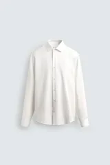 Camisa de corte relajado confeccionada en tejido fluido de lyocell, con cuello solapa, manga larga con puños abotonados y cierre frontal con botones.