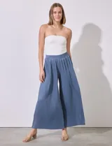 Pantalón fluido azul con pretina elastizada en punto smock y largo de pierna plisado.
