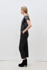 Pantalon de corte recto confeccionado en cuero ovino con acabado metalizado en color plata. Presenta cierre frontal con cremallera y bolsillos laterales.