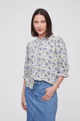 Blusa de viscosa con estampado floral, cuello a la base con detalle de volados, cierre frontal con botones y mangas tres cuartos abullonadas con puños elásticos.