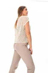 Buzo de punto calado color beige, de corte holgado y mangas cortas.