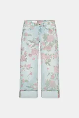 Jeans de tiro bajo, corte suelto (loose) y bajo doblado (folded). El tejido denim es de color celeste claro con un estampado integral de rosas rosadas y hojas verdes.