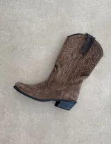 Botas de cuero color marrón y blanco con bordados negros, de estilo cowboy con taco bajo.