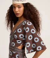 Mono largo de viscosa con estampado gráfico de soles, escote en V profundo, mangas cortas amplias y aberturas laterales en la cintura.