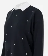 Buzo de algodón gris con cuello redondo, mangas largas con puños ajustados y aplicación de mini beads brillantes distribuidas por toda la prenda.