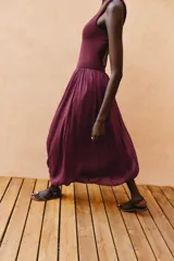 Falda midi de tiro alto con cintura elástica, diseño de pliegues verticales y bajo abullonado con elástico interior.